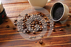 Roasted coffee beans with coffee grounds in pot on retro floor