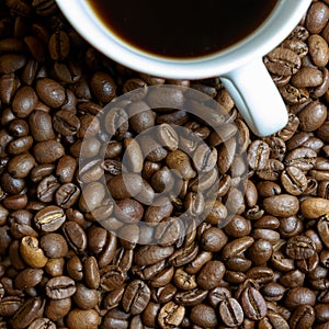 Roasted coffee beans and a cup with coffee
