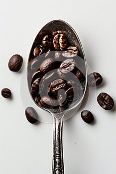 Roasted Coffee Beans Elegantly Displayed in a Vintage Silver Spoon on a White Background