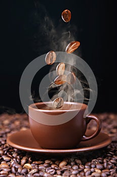 Roasted coffee beans falling into coffee cup