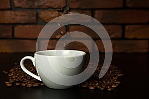 Roasted coffee beans falling into cup.