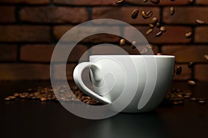 Roasted coffee beans falling into cup.