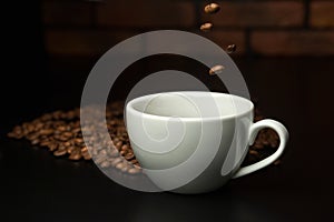 Roasted coffee beans falling into cup.