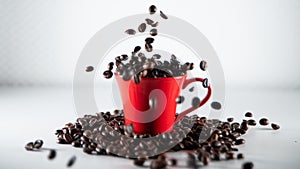 Roasted coffee beans, falling into a red coffee cup, on white background