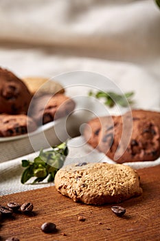 Roasted coffee beans get out of overturned glass jar on homespun tablecloth, selective focus, side view