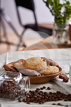 Roasted coffee beans get out of overturned glass jar on homespun tablecloth, selective focus, side view photo