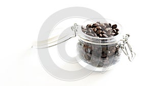 Roasted coffee beans in a glass jar.