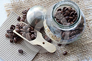 ROASTED COFFEE BEANS IN A GLASS JAR ON A TABLE TOP