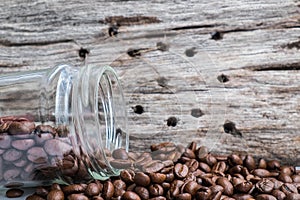 Roasted coffee beans with glass jar and wood background