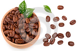 Roasted coffee beans with green leaves in wooden bowl isolated on white background. Top view