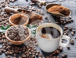 Roasted coffee beans, ground coffee and cup of coffee on wooden