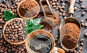 Roasted coffee beans, ground coffee and cup of coffee on wooden