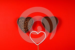 Roasted coffee beans in heart shaped bowl on red background. Love coffee concept.