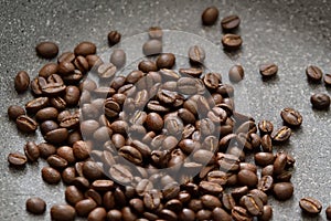 Roasted coffee beans on hot granit grey pan surface