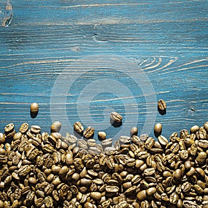 Roasted coffee beans on old blue table with copy space