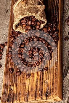 Roasted coffee beans on the old dark wooden background for wallpaper or decor