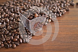 Roasted coffee beans in an old plastic box and heap of coffee pu