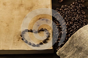 Roasted coffee beans on old vintage open book. Menu, recipe, mock up.