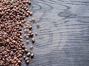 Roasted coffee beans on the old wooden background. Top view.