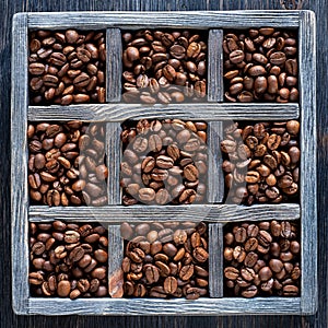 Roasted coffee beans in old wooden tray.