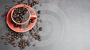 Roasted coffee beans in a red cup on black background, Top view.