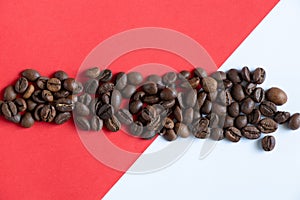 Roasted coffee beans on a red white background close-up