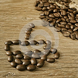 Roasted coffee beans in the shape of a cup of coffee