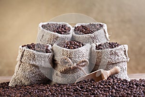 Roasted coffee beans in small burlap bags