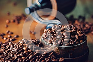 Roasted coffee beans spilled freely on a wooden table.