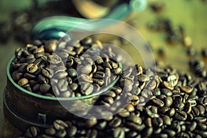 Roasted coffee beans spilled freely on a wooden table. Coffee beans in a dish for ground coffee.