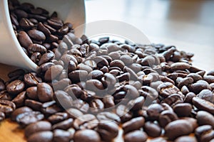 Roasted Coffee beans are spilling from the cup,  ready to give freshness and alongside the businessmen