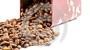 Roasted coffee beans spilling out of a metal box
