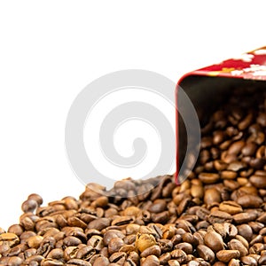 Roasted coffee beans spilling out of a metal box