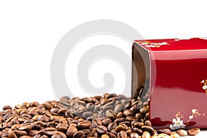 Roasted coffee beans spilling out of a metal box