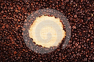 Top view with copy space, roasted coffee beans with burlap background