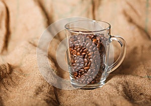 Roasted coffee beans in a transparent glass cup