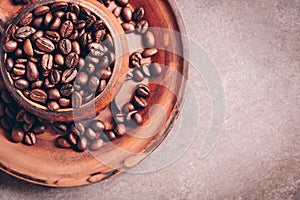 Close-up roasted coffee beans in a vintage ceramic brown cup. Symbolic image. Top view, selective focus,copy space