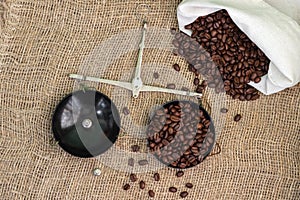 Roasted coffee beans, weighed on an antique hand scale with weights