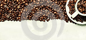 Roasted coffee beans in a white cup and saucer, gray food background, top view, flat lay
