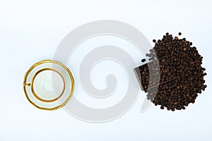 Roasted coffee beans and white porcelain cup top view on white background