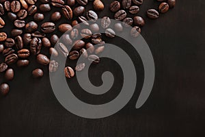 Roasted coffee beans on a wooden dark table, top view