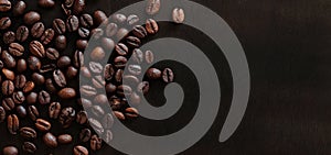 Roasted coffee beans on a wooden dark table, top view
