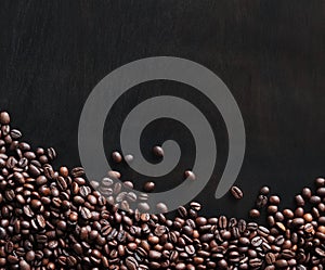 Roasted coffee beans on a wooden dark table, top view