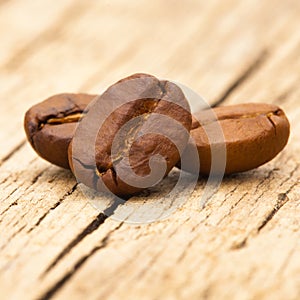 Roasted coffee beans on wooden table - close up shot