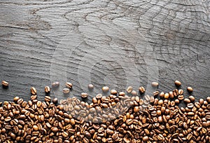 Roasted coffee beans on wooden table. Top view.