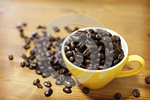 Roasted coffee beans in yellow mug.