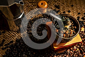 Roasted coffee seed in vintage grinder preparing to boil by espresso coffee pot photo