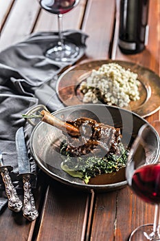 Roasted or confit Lamb Leg in pan with spinach and red wine