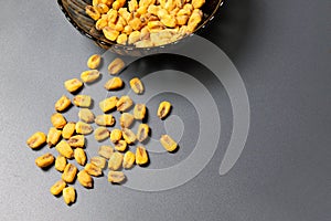 Roasted corn nuts in plate on dark background