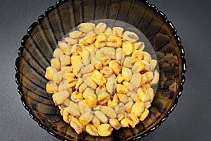 Roasted corn nuts in plate on dark background
